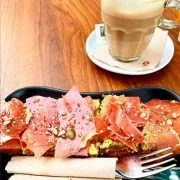 desayuno area con tostada con aceite tomate aguacate jamon serrano y semillas
